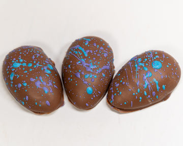 Three blue raspberry creams eggs with blue and purple splatter design 