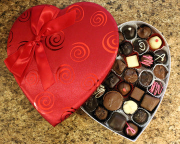 Red satin heart box filled with chocolates